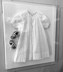 white baby dress in clear box frame